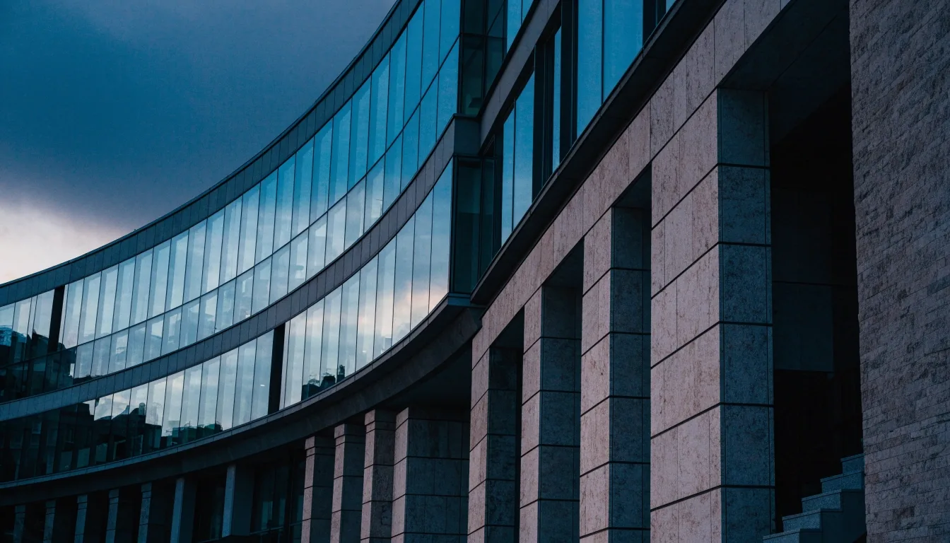 Fachada urbana de oficinas y viviendas en penumbra azulada al atardecer